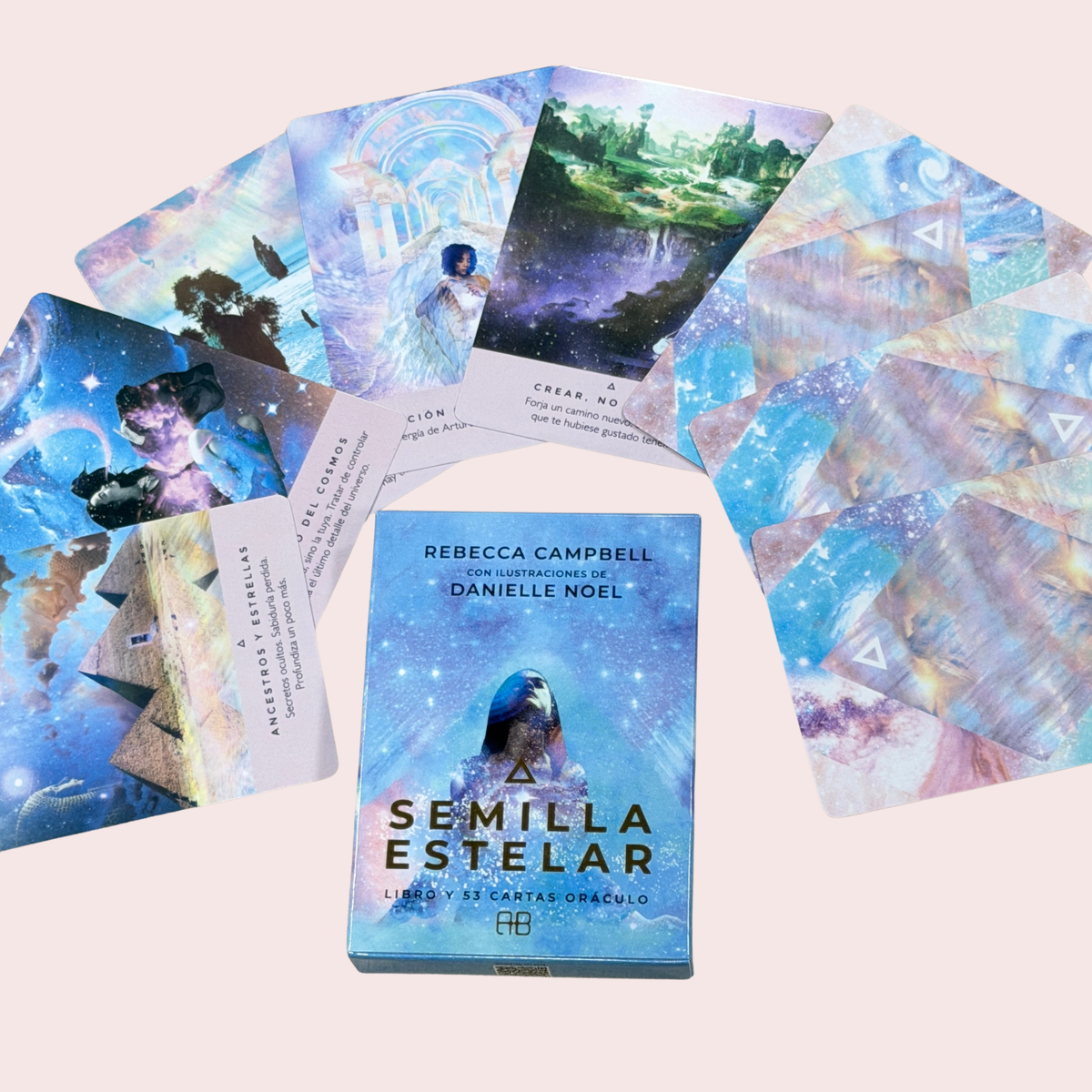 Cartas del oráculo Semilla Estelar desplegadas en abanico junto a la caja y el reverso